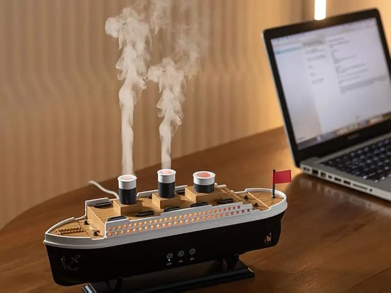 JLD Titanic Ship Diffuser releasing mist through steam chimneys with glowing LED lights—an elegant aromatherapy device combining classic design with modern wellness.