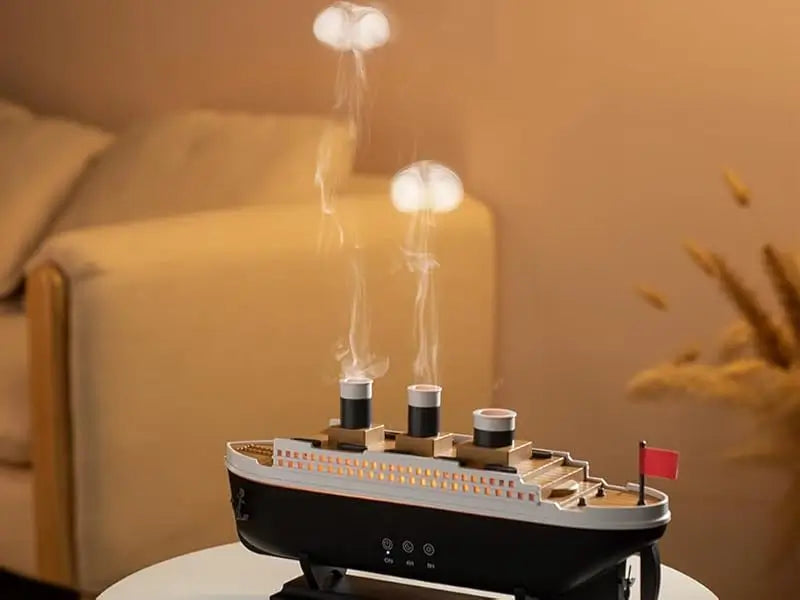 JLD Titanic Ship Diffuser releasing mist through steam chimneys with glowing LED lights—an elegant aromatherapy device combining classic design with modern wellness.